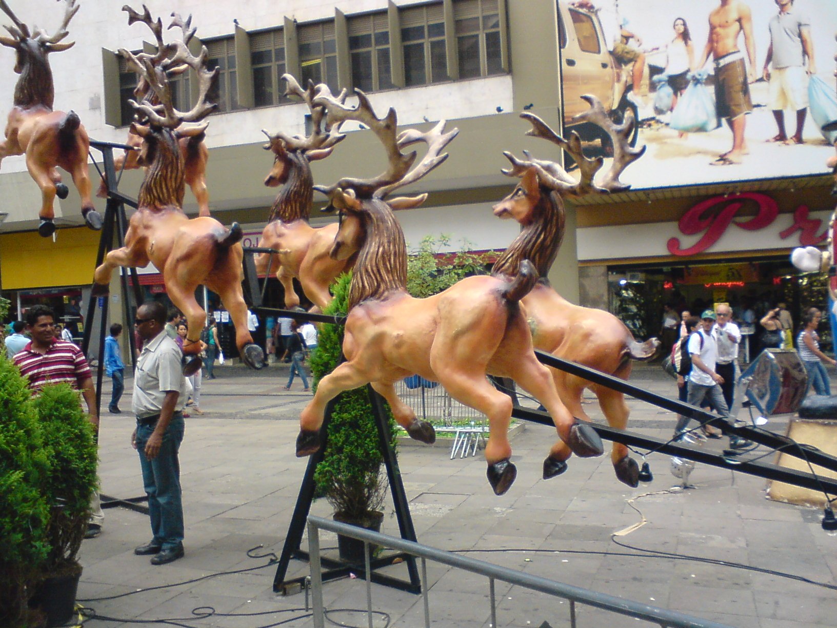 Renas decorativas de Natal expostas em calçada de rua comercial
