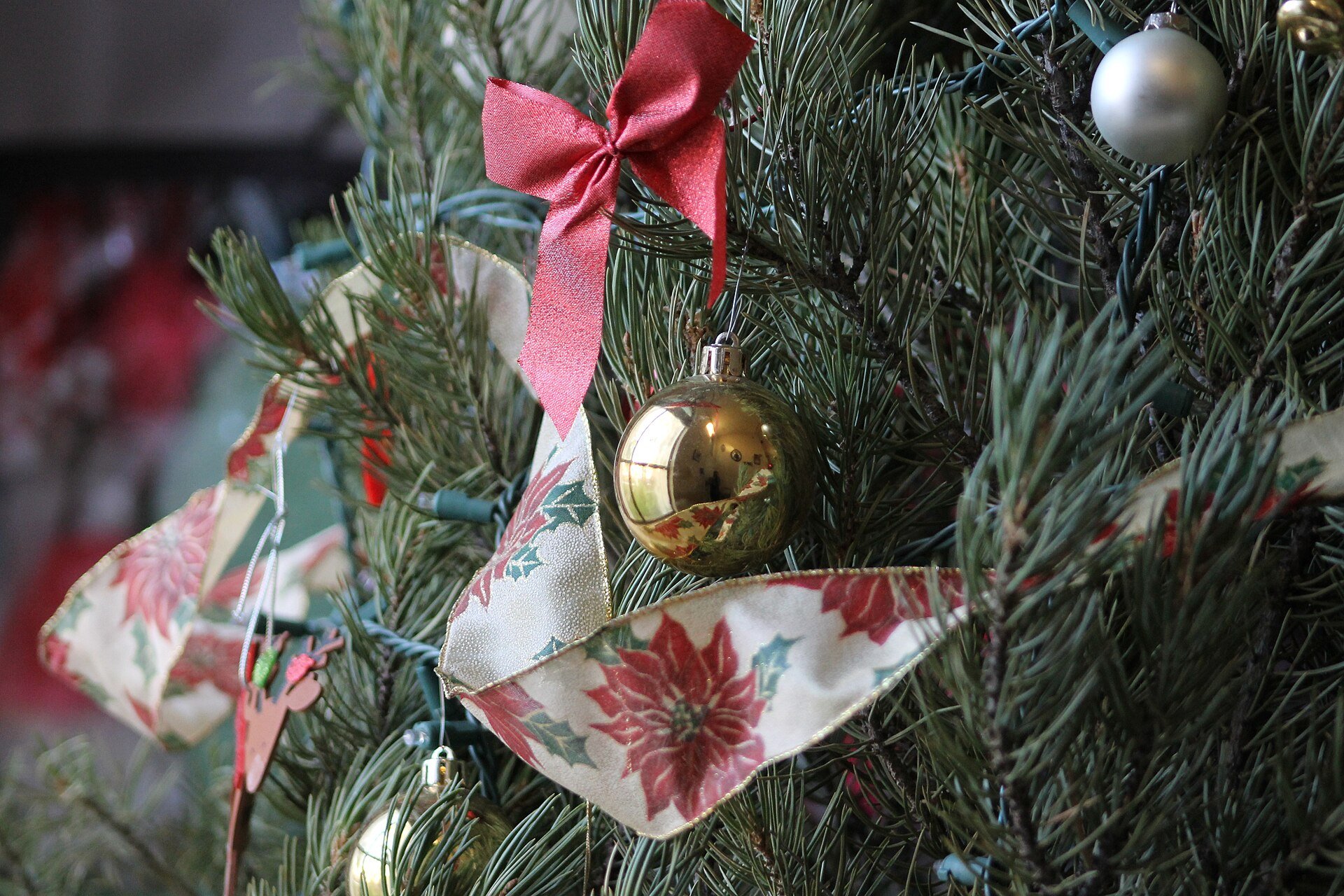Enfeite dourado pendurado em galho de árvore de Natal