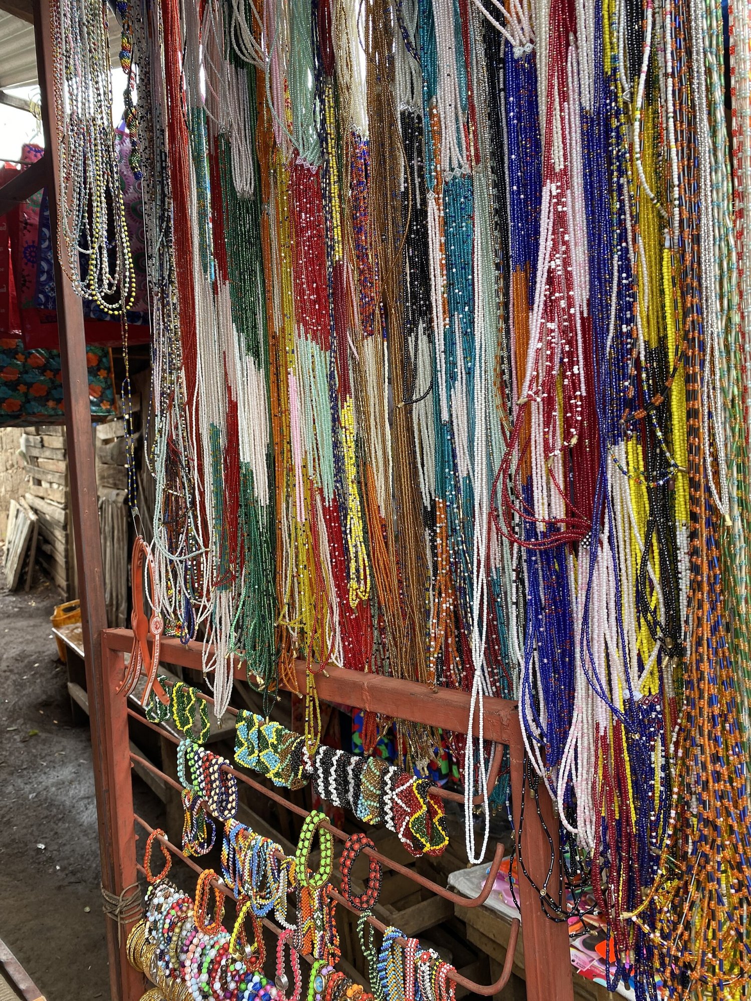 Banca com colares, pulseiras e brincos de miçangas coloridas expostos para venda