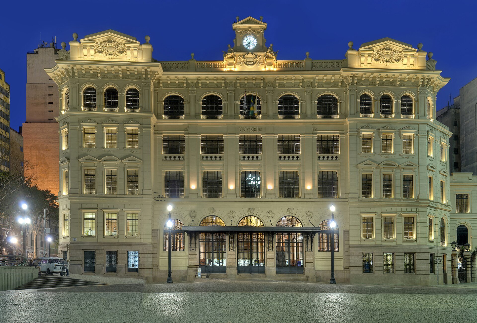 Fachada iluminada do Palácio dos Correios, no Vale do Anhangabaú, ao anoitecer
